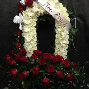 Arrangement floral 'Porte du Ciel' avec fleurs formant une porte ouverte, symbole de passage vers l'au-delà.