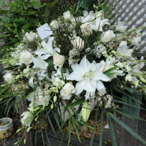 Une gerbe de fleurs délicates, symbole de respect et d'hommage. Elle apporte sérénité et beauté en hommage à l’être cher, offrant réconfort et soutien aux proches lors du deuil.