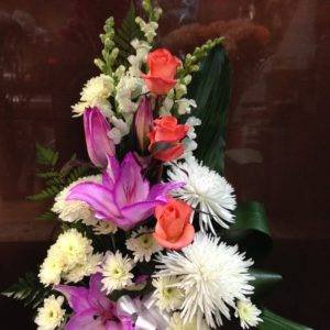 Arrangement floral élégant avec une base mauve, rouge et blanche, composé de fleurs raffinées pour une touche sophistiquée et harmonieuse.