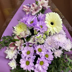 Bouquet de fleurs Mauve et Blanc #3 de Fleuriste La Romaine avec gerberas blancs, chrysanthèmes mauves et alstroemerias dans un emballage violet.