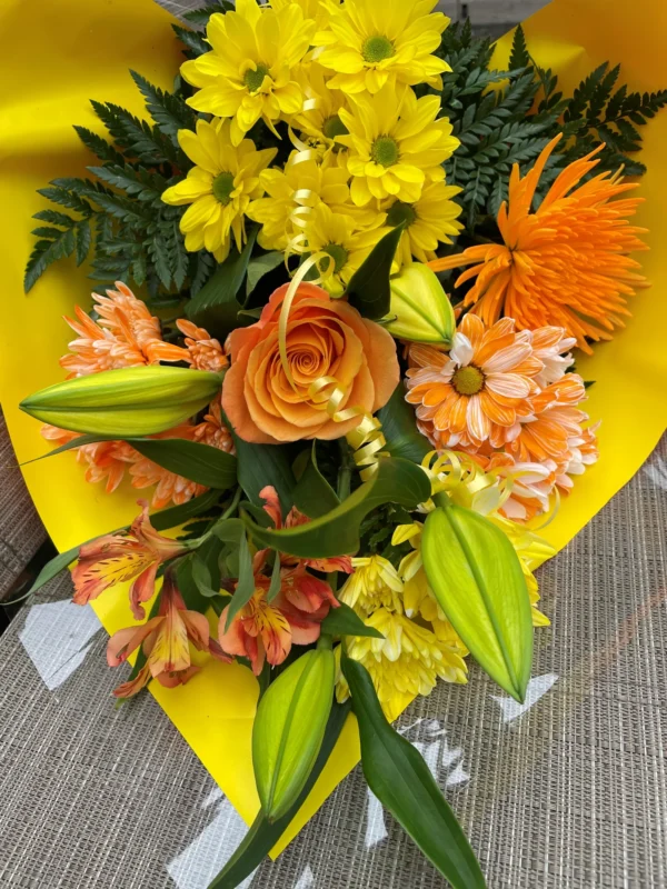 Un arrangement vibrant d'orange et de jaune, symbolisant l'énergie et la joie. Parfait pour les événements festifs ou pour ajouter une touche de chaleur et de convivialité à toute occasion.